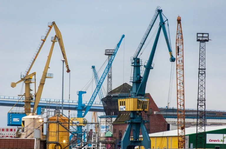 Shipping containers at a busy port representing U.S.-Canada trade and the impact of tariffs on the automotive industry.